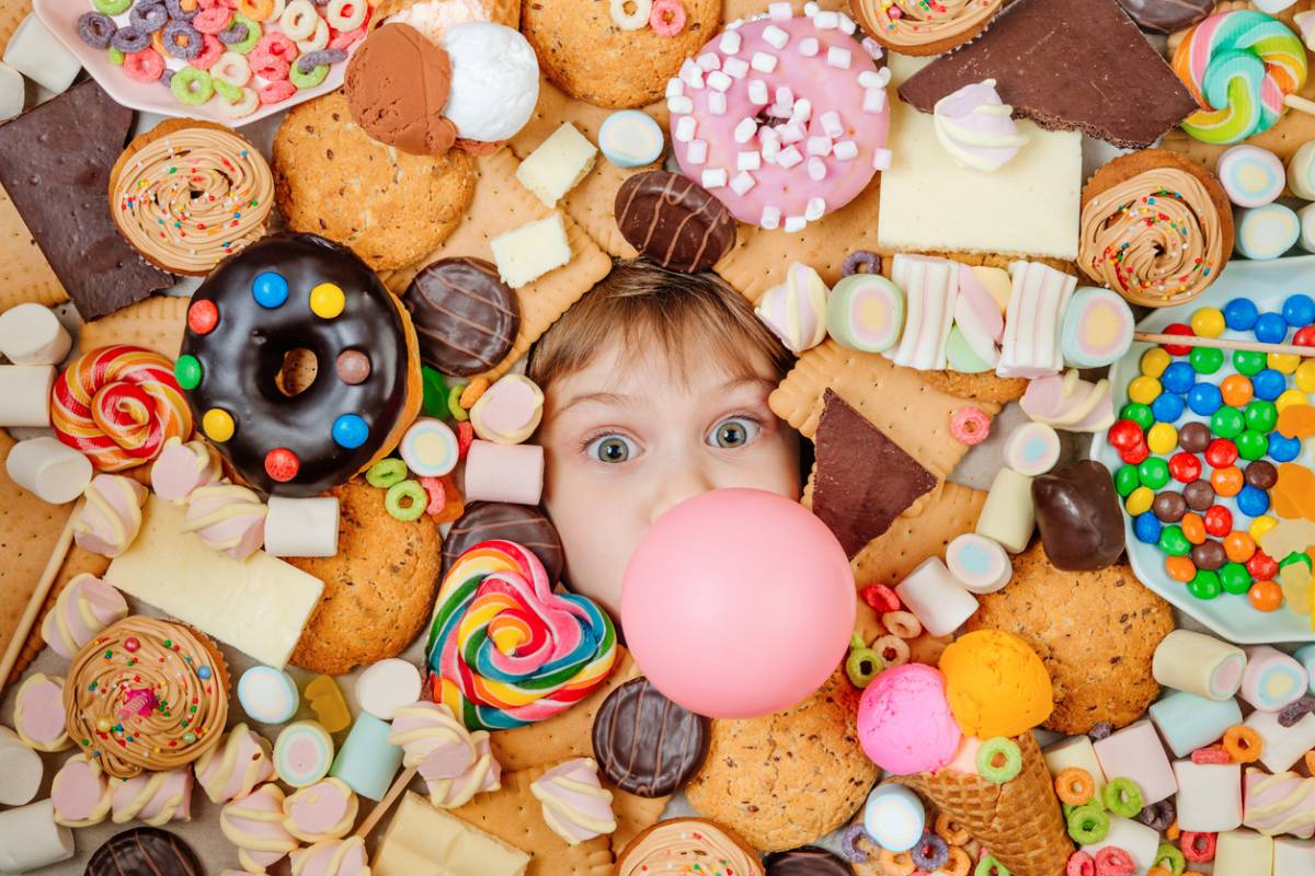 Kids face surrounded by unhealthy, sugary food.